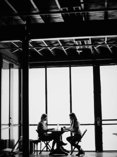 Imagem de duas pessoas conversando em uma mesa